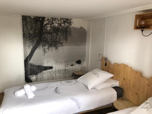 een slaapkamer met een bed met een foto aan de muur bij Le gite du Frene in Poses