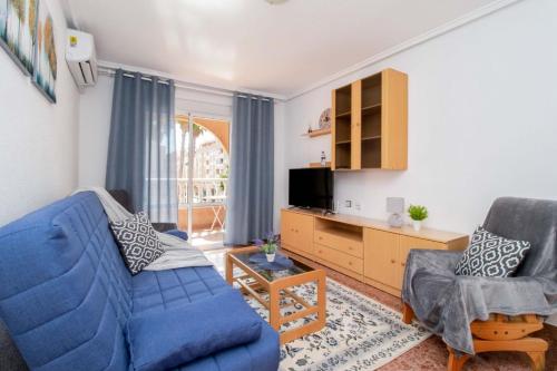 a living room with a blue couch and two chairs at Apartamentos Villa Madrid in Torrevieja