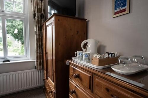 a bathroom with a counter with a sink and a cabinet at Meadowcroft Guest House in Windermere