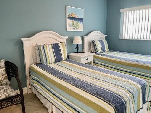 Duas camas num quarto com paredes azuis em Beach Front Villa - Right On The Beach! em Holmes Beach