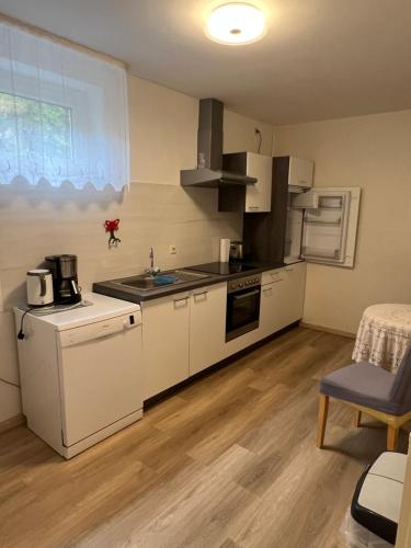 eine kleine Küche mit weißen Geräten und einem Tisch in der Unterkunft Ferienapartment Lidia in Kastellaun