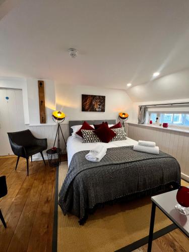 a bedroom with a large bed and a chair at The Lion, Tredington in Shipston on Stour