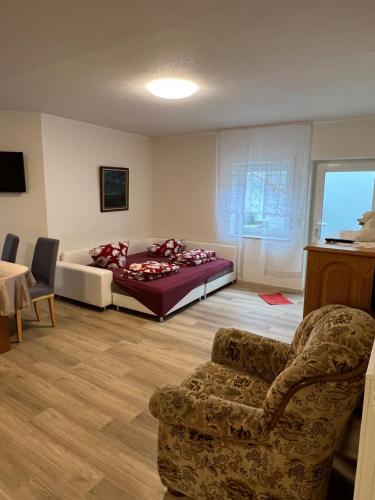 ein Schlafzimmer mit einem Bett, einem Sofa und einem Stuhl in der Unterkunft Ferienapartment Lidia in Kastellaun
