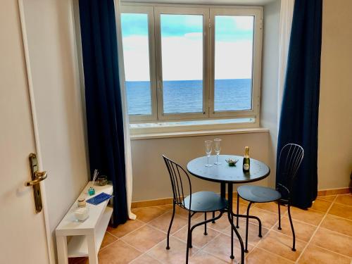 a table and chairs in a room with a window at Artis Mare in Pozzuoli