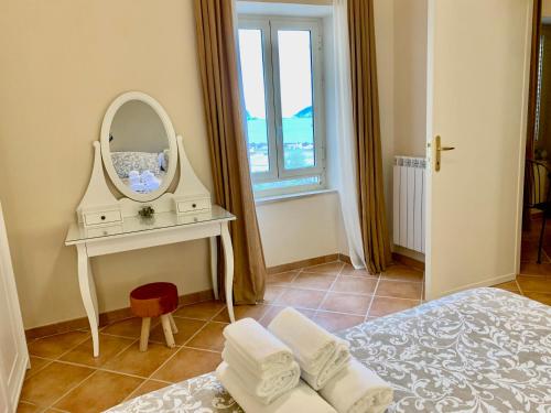 a bedroom with a bed and a dressing table with a mirror at Artis Mare in Pozzuoli