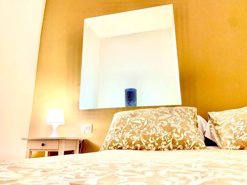 a bedroom with a bed with a mirror on the wall at Artis Mare in Pozzuoli