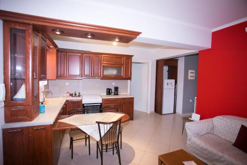 a kitchen with wooden cabinets and a table and chairs at Estia's House in Ágios Prokópios