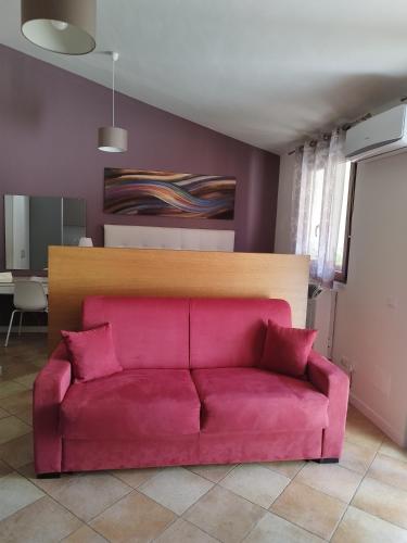 a pink couch sitting in a living room at Casa Nicole in Castelbuono