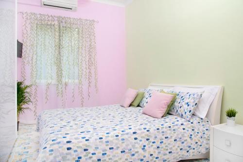 a pink and white bedroom with a bed with pillows at Luigi's room - De Vivo Realty Meta di Sorrento in Meta