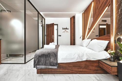 a bedroom with a large bed and a glass wall at MiM Apartments in Skopje