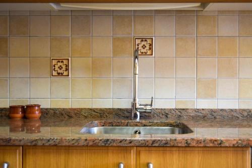 um lavatório numa cozinha com azulejos na parede em Casa Rural Martín em Tronchón