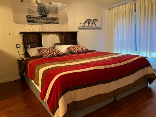 a bedroom with a large bed with a horse picture on the wall at Cozy Balcony apartment in Morningside in Sioux City