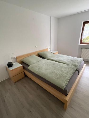 1 dormitorio con 1 cama grande con marco de madera en Schöne 2-Zi-Whg, sehr gut ausgestattet, en Hemmingen