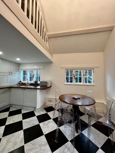a kitchen with a table and chairs on a checkered floor at The Lion, Tredington in Shipston on Stour