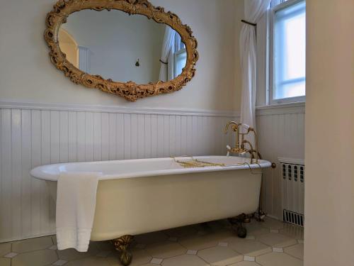 a white bath tub in a bathroom with a mirror at Stanton House Inn in Greenwich