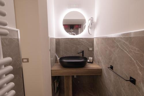 a bathroom with a black sink and a mirror at Maximum Exclusive Suite & Spa in Palermo