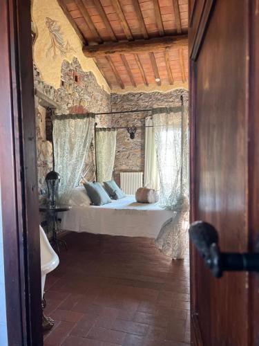 a bedroom with a large bed in a stone room at Corte Dei Folletti in Lucca