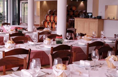a dining room with white tables and chairs and wine barrels at Agritur Acetaia Gourmet&Relax in Tenno