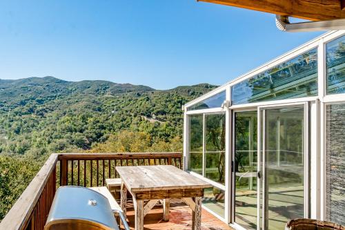 a wooden table on a balcony with a view of the mountains at Hilltop Heaven in Atascadero