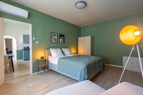 een slaapkamer met een bed en een groene muur bij Sunny new luxurious home at the Jewish district in Boedapest