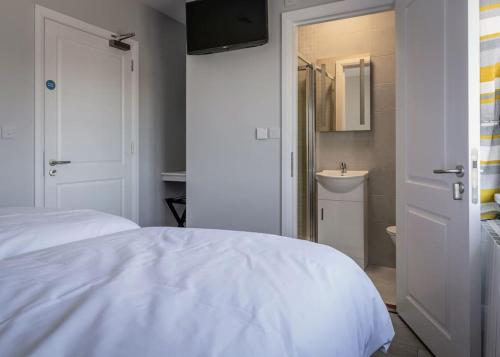 a bedroom with a bed and a bathroom with a sink at Burrows Lodge in Waterford