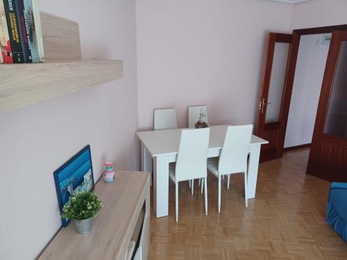 a dining room with a white table and white chairs at Xuan Inn - Garaje incluido in Avilés