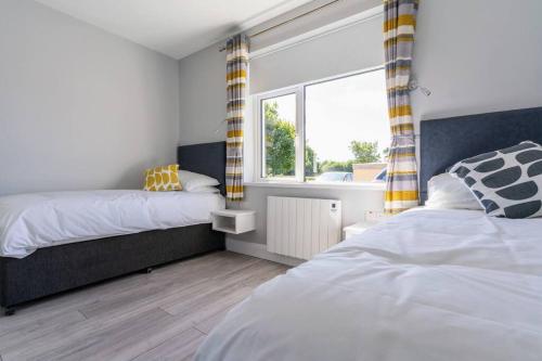 1 dormitorio con 2 camas y ventana en Burrows Lodge, en Waterford