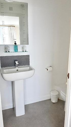 a white bathroom with a sink and a mirror at Palma Guest House in St Ives