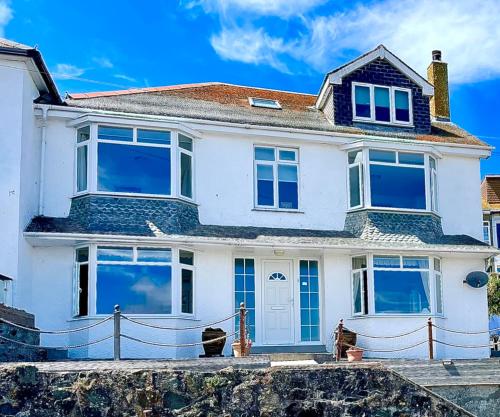 a white house with blue doors and windows at Palma Guest House in St Ives