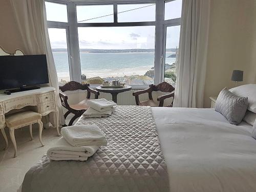 a bedroom with a bed with a view of the ocean at Palma Guest House in St Ives