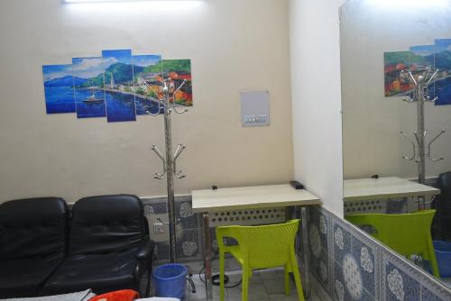 a waiting room with two chairs and a table and a pole at Homestay 3 in Dhaka