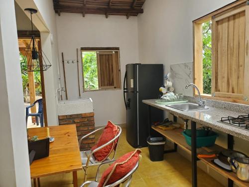 een keuken met een koelkast en een tafel en stoelen bij Villa Nico hospedaje campestre in Bochalema