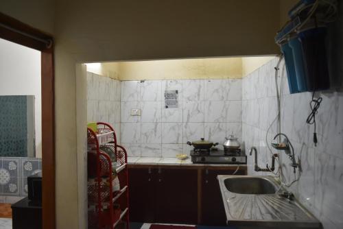 a small kitchen with a sink and a stove at Homestay 3 in Dhaka