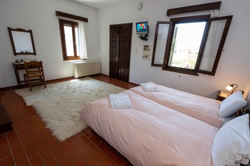 a bedroom with a large white bed and windows at Zmas Studios in Chorto