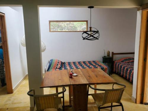 a room with a wooden table and chairs and a bed at Hotel Campestre Villa Nico in Bochalema