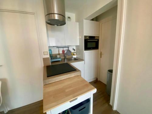 une cuisine avec des armoires blanches et un comptoir dans l'établissement Vue mer L'aiglon T2 Balcon parking privé, à Wimereux