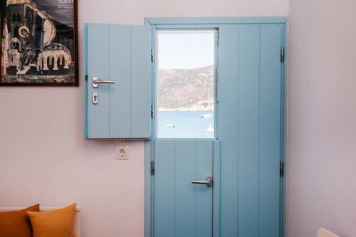 Habitación con puerta azul y ventana en Loukas and Margarita's house en Platís Yialós Sifnos