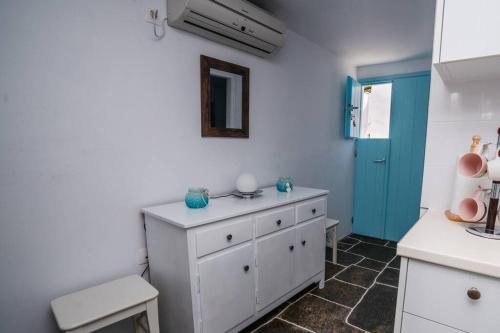 una cocina con una cómoda blanca y una puerta azul en Loukas and Margarita's house en Platis Yialos Sifnos