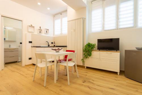 cocina y comedor con mesa blanca y sillas en Italianflat - Vittoria Suite, en Milán