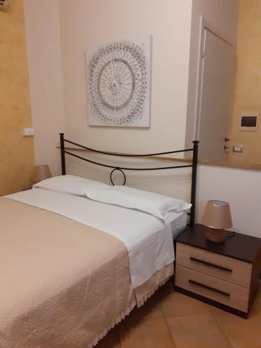 a bedroom with a white bed and a nightstand with a bed sidx sidx sidx at Casamia in Portopalo