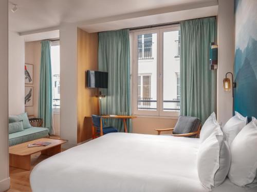 Cette chambre comprend un grand lit et une fenêtre. dans l'établissement Hôtel Edgar & Achille, à Paris