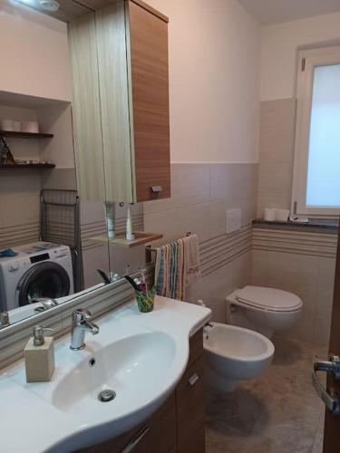 a bathroom with a sink and a toilet and a mirror at La corte in Vezzo