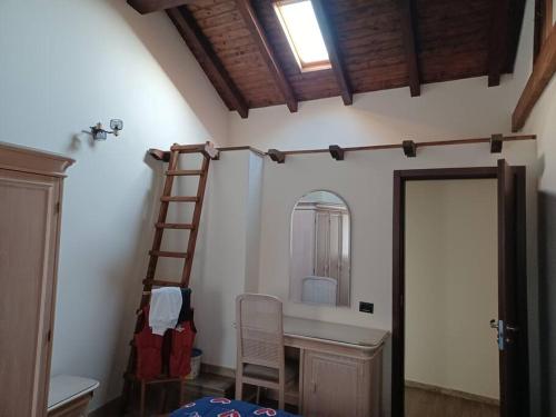 Zimmer mit einer Leiter und einem Spiegel an der Wand in der Unterkunft La corte in Vezzo