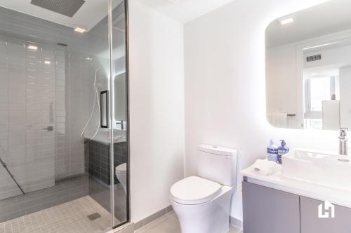 a white bathroom with a toilet and a shower at Downtown Miami Condos by Lua Host in Miami