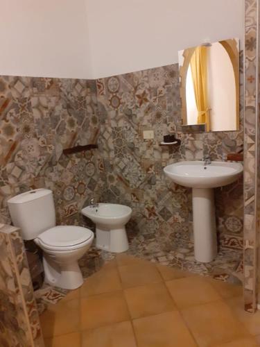 a bathroom with two toilets and a sink at Casamia in Portopalo