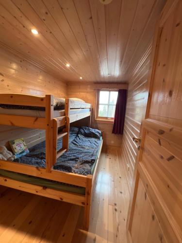 a log cabin with two bunk beds in it at Perlen på solheim I Hyen in Vereide