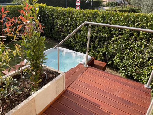 a jacuzzi tub on a wooden deck at Lake Front Luxury Apartment in Sirmione