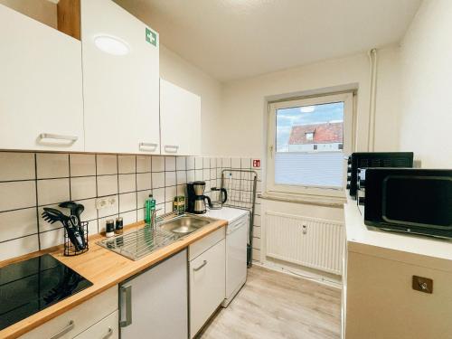 a kitchen with a sink and a microwave at Monty - Kitchen - Washer - Free Parking - SMART-TV in Goslar