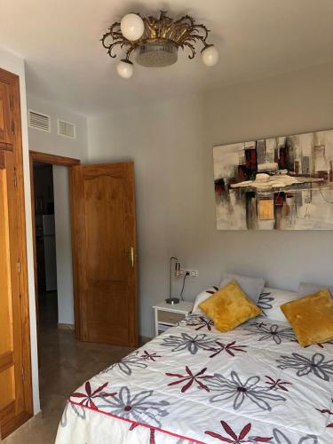 1 dormitorio con cama y lámpara de araña en Apartamento Navas, en Frigiliana