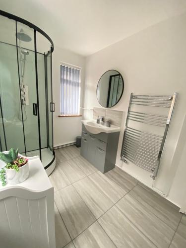 uma casa de banho com um chuveiro, um lavatório e um espelho. em Gatwick Studio em Horley